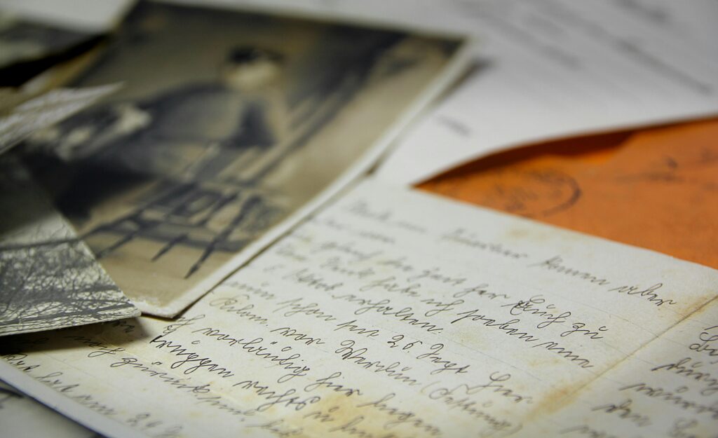 Old handwritten letters and vintage photographs spread on a table, creating a nostalgic feel.